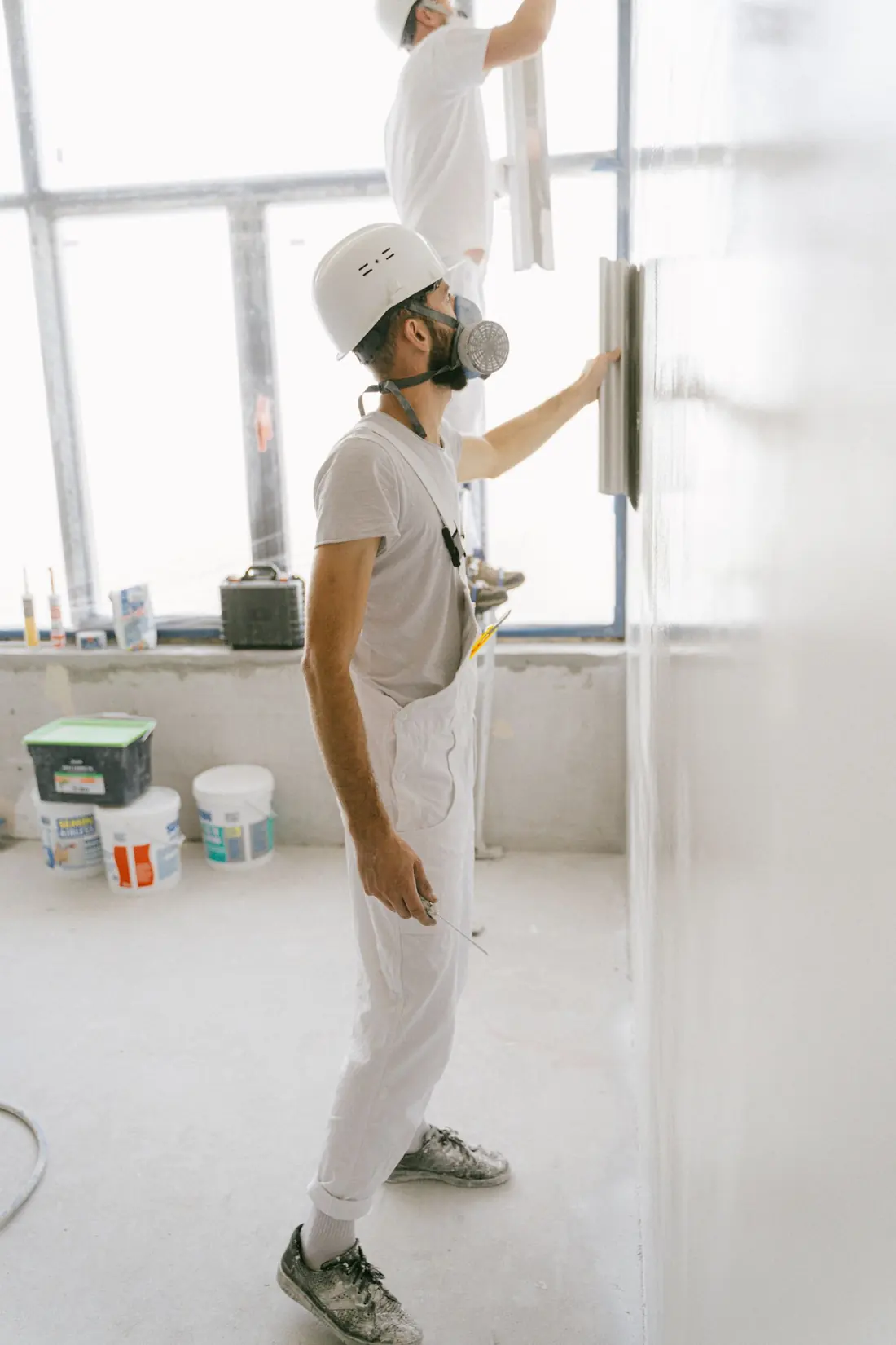 Ravalement de façade — applicateurs posant l'enduit sur un mur en rénovation